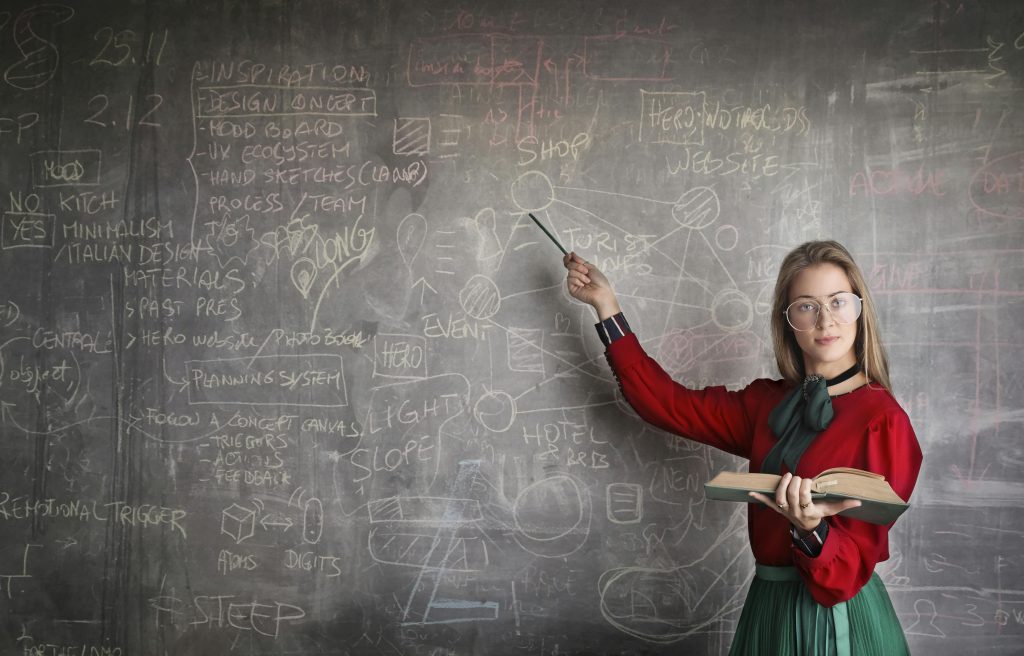 Woman pointing a physics equations on blackboard