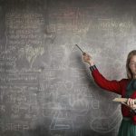 Woman pointing a physics equations on blackboard
