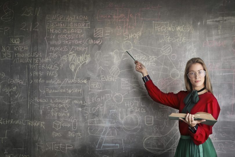 Woman pointing a physics equations on blackboard